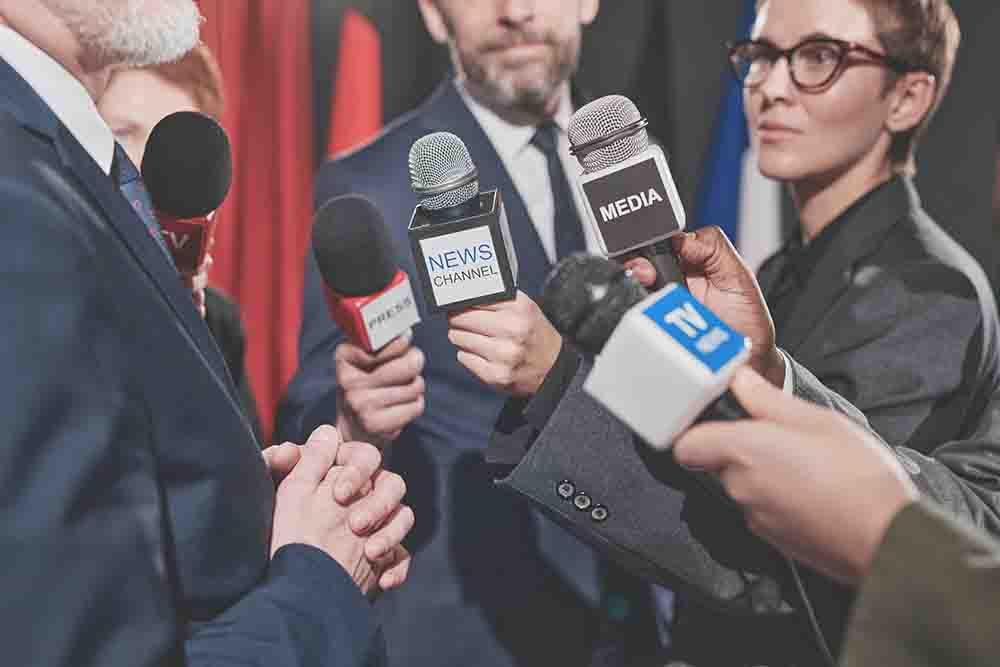 Journalists interviewing businessman at conference